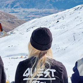 Four young girls watching the action on the ski fields from the top of the mountain