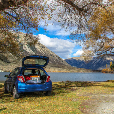 Rental car parked at lakeside, South Island New Zealand