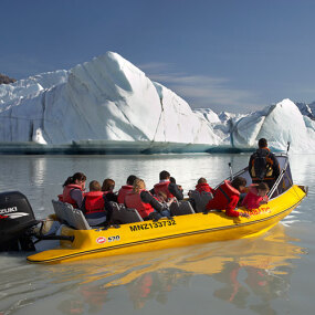Tourists on boat on glacier lake in Mt. Cook National Park