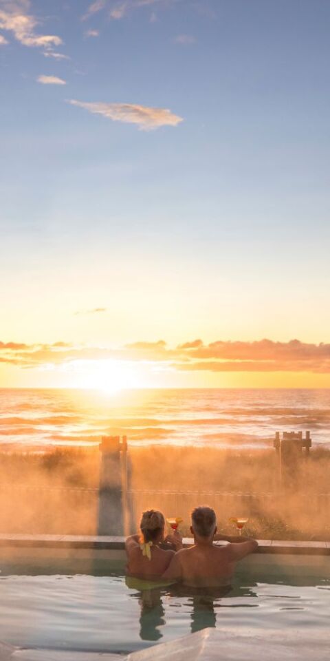 Couple overlooking the sea from a pool - credit to Miles Holden