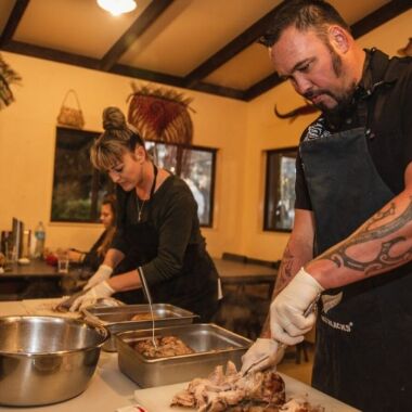 Man and woman cutting hangi meal
