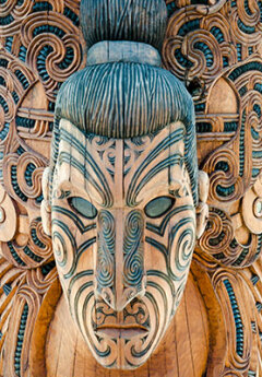 Intricately carved Māori mask with traditional patterns and detailed woodwork.