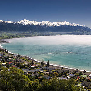 Aerial view of seaside town Kaikoura with snowcapped mountains at the background