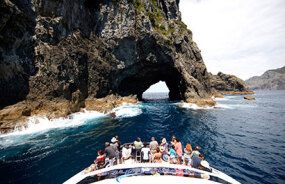Catamaran sailing through Hole in the Rock Bay of Islands