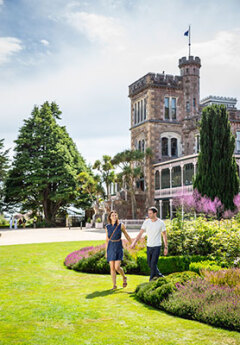 Couple walking from Larnach castle on a sunny day