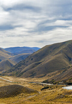 Scenic drive through Lindis Pass and view of brown hills