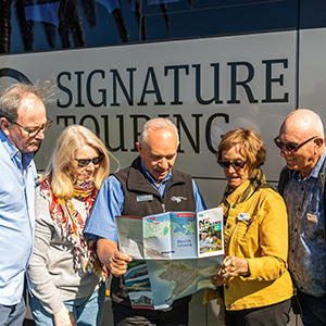 Image of a group of travelers in front of Grand Pacific Signature Touring coach