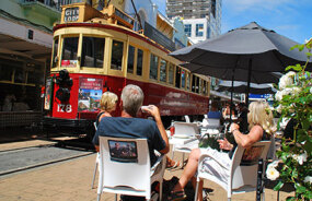 People relaxing and watching the tram in Christchurch