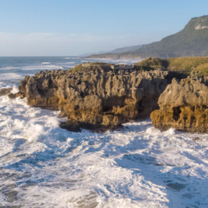 Choppy waves hit a large cliff face