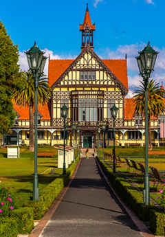 The historic Rotorua Museum with orange tiled roof and with walls and pristine gardens