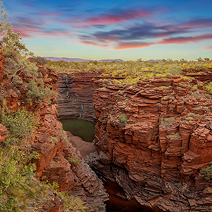 Towering red cliff faces overlook the junction of a gorge at Oxers Lookout in Karijini National Park