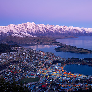 View over Queenstown during sunset and snowcapped Remarkables at the background