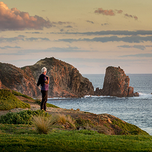 Person looking over the rock face at Cape Woolamai at dusk