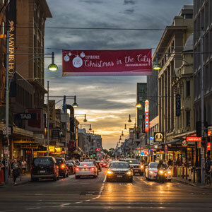A busy street at dusk with car headlights reflecting off the road