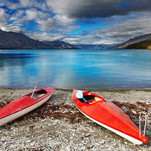 Orange kayaks on the stoney shores of Lake Wakatipu