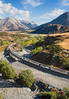 Tranzalpine train crossing the Cass River and heading towards the mountains