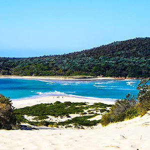 A body of water runs between two sandy white beaches in Port Stephens
