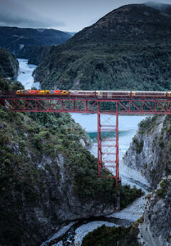 Tranzalpine train crossing a staircase viaduct over a river