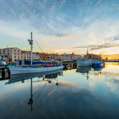 Boats docked in the harbour with historic buildings in the back