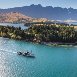 The TSS Earnslaw cruises along Lake Wakatipu, with the Remarkable Mountains in the background.