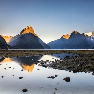 A view of Milford Sound at sunrise, the staggering Mitre PEak reflected in the still waters.