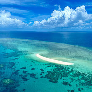 Aerial view of a coral cay in the bright blue waters of the great barrier reef