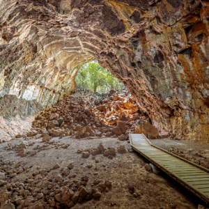 Large lava caves with boardwalk and rocks in the back