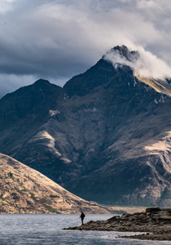 Man standing at the shores of Lake Wakatipu near Queenstown.