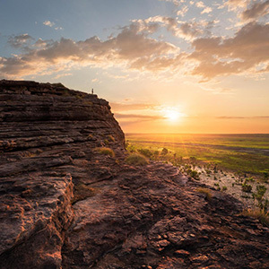 Sunset over rocky outcrop and vast wetlands.