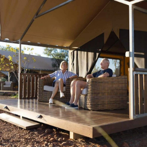 Man and Femal sitting on arm chairs on the deck at Bell Gorge Wilderness Lodge