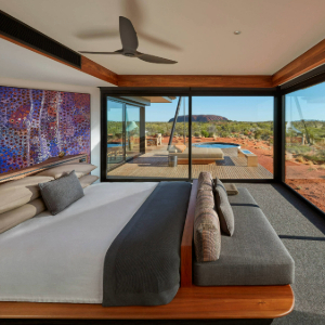 Bed with couch and deck with pool and uluru in the back