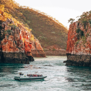 Boat in the water at Horizontal falls with large stony cliffs