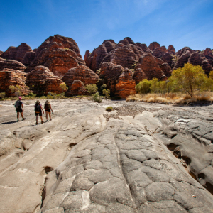 Beehive shaped mounds with three people walking