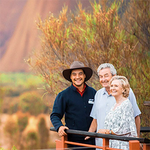 Guide and guests smile in from viewing balcony at Uluru.