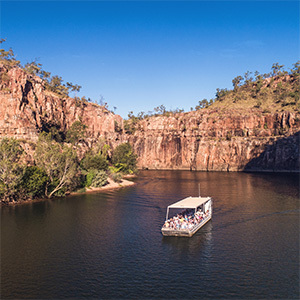 Boat on dark water between rocky gorges.