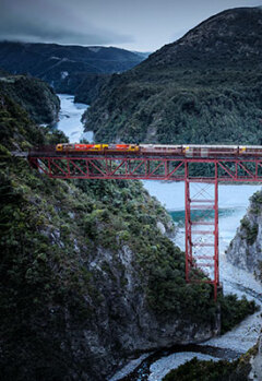 View of TranzAlpine train riding across a river