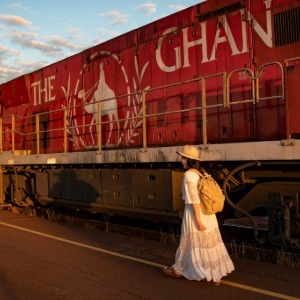A woman walks beside the iconic red Ghan train engine.