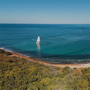 Aerial view of a catamaran on clear water.