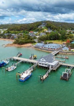 An aerial view of a small wharf with boats in the Bay of Islands.