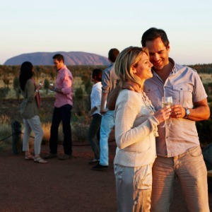 A couple sips champagne while enjoying the Uluru sunset.