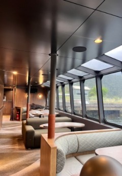 The interior of a premium boat with tables and seating