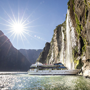 Mountains rising above a cruise boat on Milford Sound