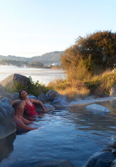 A couple relaxing in a Polynesian Spa, Rotoroa