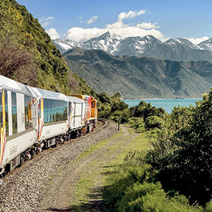 Coastal Pacific Scenic Train heading towards snowcapped mountains