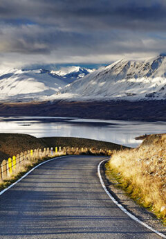 Road heading to Lake Tekapo and Mount Cook National Park in the back