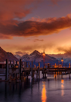 Queenstown wharf and snowwcapped mountain during sunset