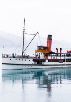 The TSS Earnslaw floats on the water towards Walter Peak