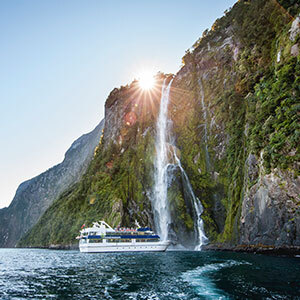 View of a boat and waterfall in Milford SOund