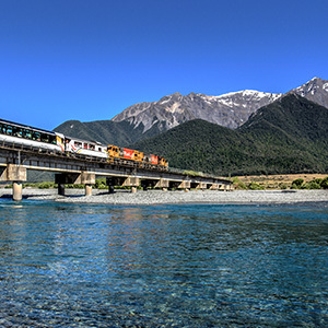 Tranzalpine train crossing a bridge on a sunny day, New Zealand