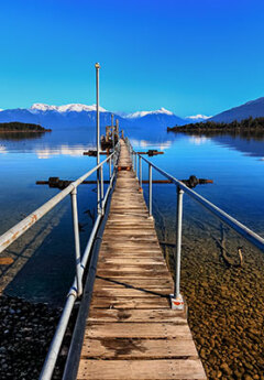 Te Anau jetty and snow-capped mountains of Fiordland National Park in the background